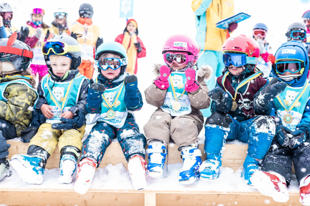 Enfants en cours de ski et snowboard à la saison le dimanche matin à Villars